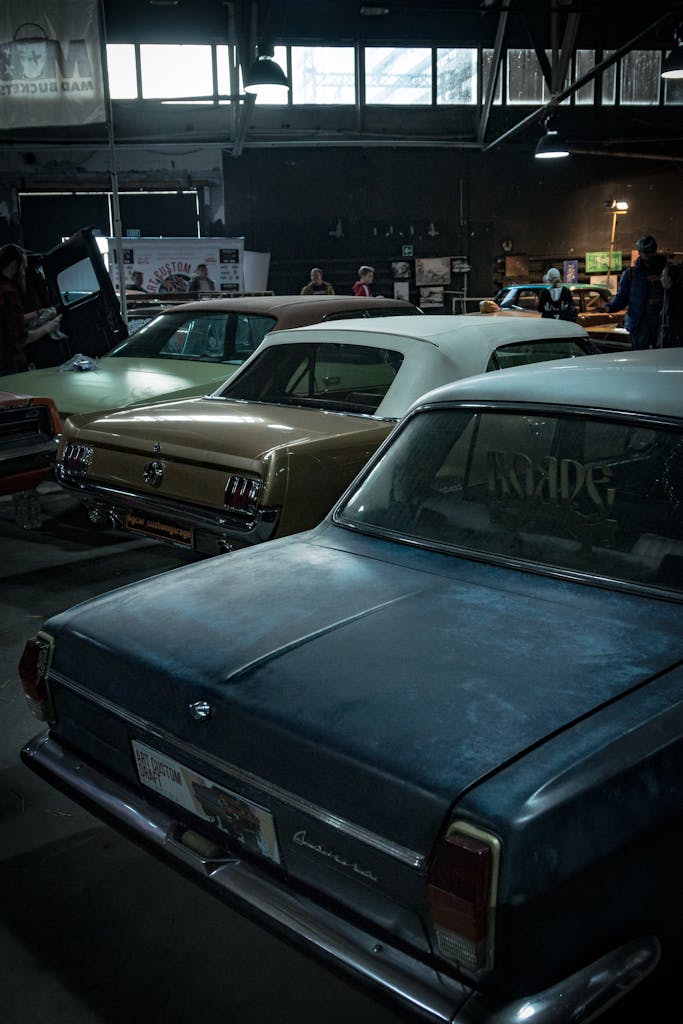 A collection of vintage cars on display indoors, highlighting classic automotive design.