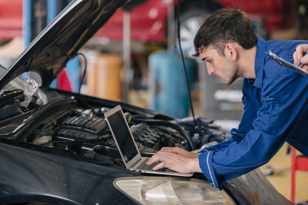 Service advisor using auto repair scheduling software to manage shop workload