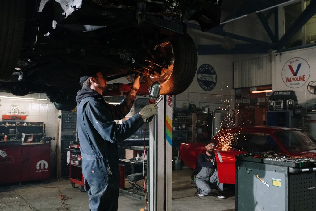 Repair shop technicians working together on a vehicle