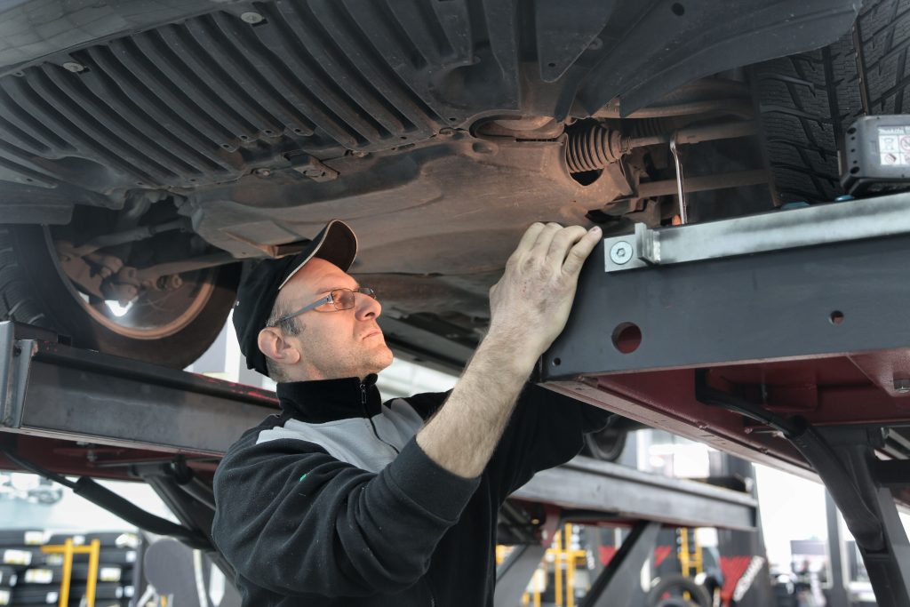 Auto repair technician working on a vehicle during a scheduled repair