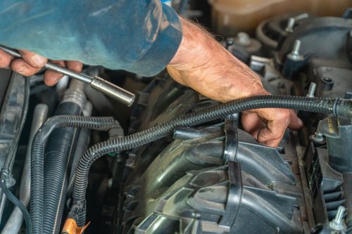 Auto repair technician performing vehicle service within a connected shop workflow