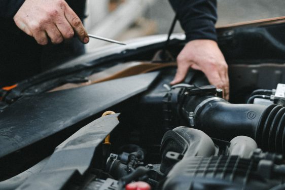 Auto repair technician performing vehicle service in a repair shop