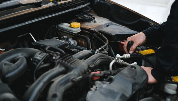 Auto repair technician performing vehicle service during a busy shop day {{brizy_dc_image_alt imageSrc=
